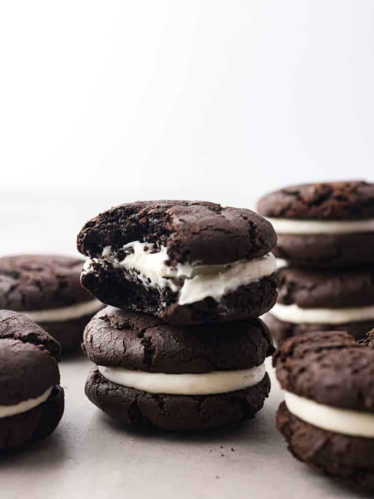 Get ready to enjoy the best homemade cookie out there! These homemade cakesters are perfectly soft on the outside and filled with the BEST creamy, oreo filling. You won't be able to stop at just one! A stack of oreo cakesters with a bite taken out of the top one.