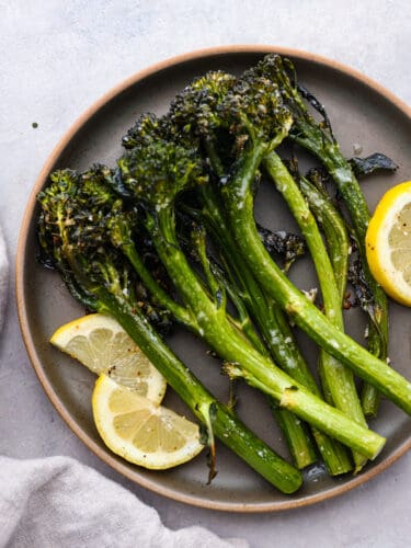 If you are looking for the perfect side dish that pairs well with everything, this lemon garlic broccolini is it! It's seasoned with delicious flavors and roasted to perfection! A plate of roasted lemon garlic broccolini.