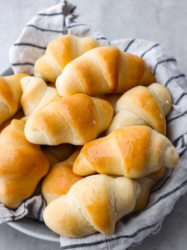If you are looking for the perfect roll that goes with every single meal, then you've found it! These homemade crescent rolls are soft, golden brown, and have a delicious and buttery taste. The top view of a bowl of crescent rolls.